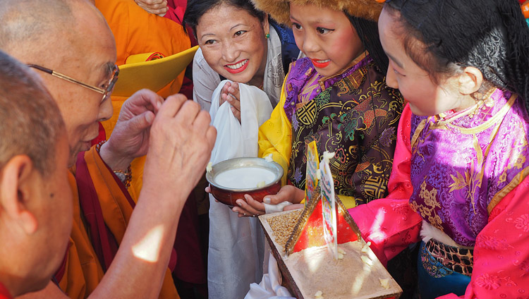 Due bambine tibetane, in abito tradizionale, offrono a Sua Santità il Dalai Lama il tradizionale benvenuto al suo arrivo al monastero di Sera Mey a Bylakuppe, 21 dicembre 2017. Foto di Jeremy Russell