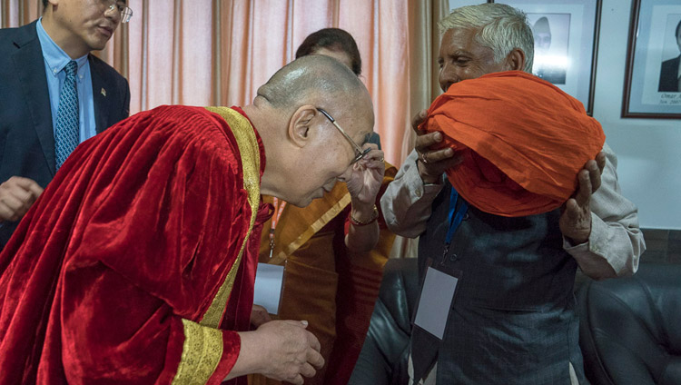 Sua Santità il Dalai Lama indossa gli abiti accademici prima di prendere parte alla Prima cerimonia di laurea dell'Università Centrale di Jammu, India, 18 marzo 2018. Foto di Tenzin Choejor