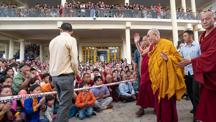 Sua Santità il Dalai Lama saluta la folla nel cortile del Tempio Tibetano Principale, mentre fa ritorno alla sua residenza, al termine degli insegnamenti agli studenti tibetani, presso il Tempio Tibetano Principale di Dharamsala, India, 8 giugno 2018. Foto di Tenzin Choejor