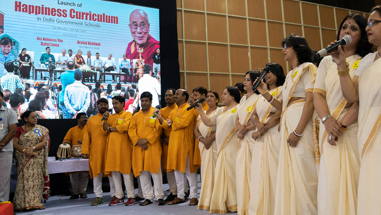 Un gruppo di insegnanti intona una canzone di benvenuto composta da loro in occasione del lancio del “Curriculum della Felicità” nelle scuole pubbliche di Delhi. Nuova Delhi, India, 2 luglio 2018. Foto di Tenzin Choejor