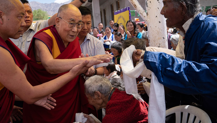 Sua Santità il Dalai Lama saluta gli anziani tibetani mentre arriva alla scuola Choglamsar del Tibetan Children's Village a Leh, Ladakh, India, il 1° agosto 2018. Foto di Tenzin Choejor