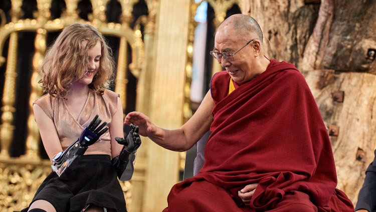 Sua Santità il Dalai Lama osserva le protesi bioniche di Tilly Lockey durante la discussione su "Robotica e telepresenza" alla Nieuwe Kerk di Amsterdam, Paesi Bassi, il 15 settembre 2018. Foto di Olivier Adam