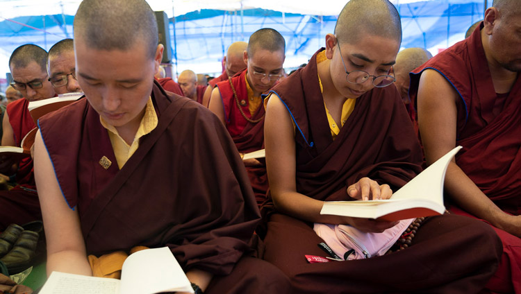 Le monache seguono il testo durante la seconda giornata di insegnamenti di Sua Santità il Dalai Lama a Manali, India, il 14 agosto 2019. Foto di Tenzin Choejor