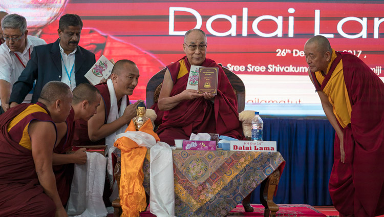 Sua Santità il Dalai Lama presenta i libri prodotti e pubblicati dal monastero di Sera Jey prima del suo discorso alla Tumkur University di Tumakuru, 26 dicembre 2017. Foto di Tenzin Choejor