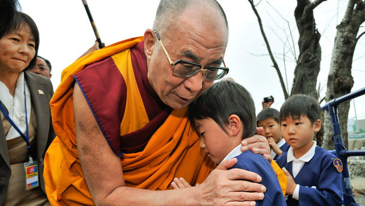 Sua Santità il Dalai Lama durante la sua visita nella regione del Sendai (Giappone) devastata dallo tsunami, mentre conforta un piccolo sopravvissuto il 5 novembre 2011. (Foto di Tenzin Choejor/OHHDL)