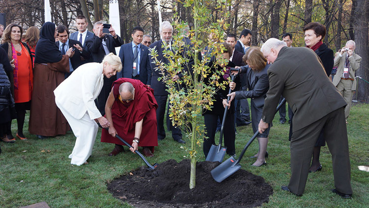 Betty Williams, Sua Santità il Dalai Lama, Shirin Ebadi, Mairead Maguire e Lech Walesa mentre piantano un albero dopo il 13° Summit dei Nobel per la Pace a Varsavia (Polonia), il 23 ottobre 2013 (Foto di Jeremy Russel/OHHDL)
