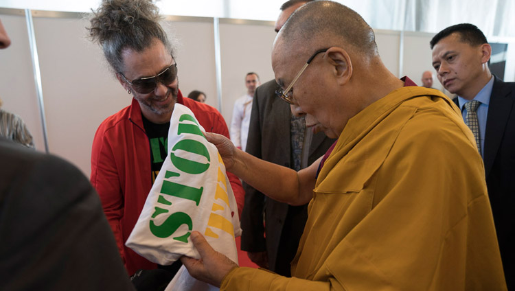 Sua Santità il Dalai Lama riceve in dono da un rapper lettone una maglietta con la scritta “Stop War”, al termine dell’incontro con la comunità tibetana a Riga, il 24 settembre 2017. Foto di Tenzin Choejor