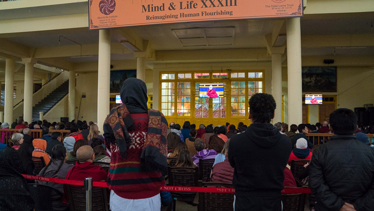 Il pubblico ascolta Sua Santità il Dalai Lama grazie agli schermi posti nel cortile del Tempio Tibetano Principale, il quarto giorno della Mind & Life Conference a Dharamsala, India, 15 marzo 2018. Foto di Tenzin Choejor