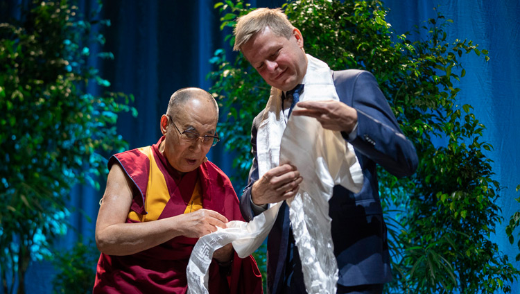 Sua Santità il Dalai Lama spiega il significato della sciarpa bianca che ha donato al sindaco di Vilnius, Remigijus Šimašius, all’inizio della conferenza pubblica a Vilnius, in Lituania, il 14 giugno 2018. Foto di Tenzin Choejor