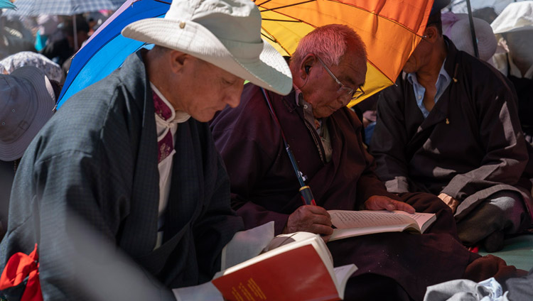 La folla segue il testo durante l'ultima giornata di insegnamenti di Sua Santità il Dalai Lama a Leh, Ladakh, India, il 31 luglio 2018. Foto di Tenzin Choejor