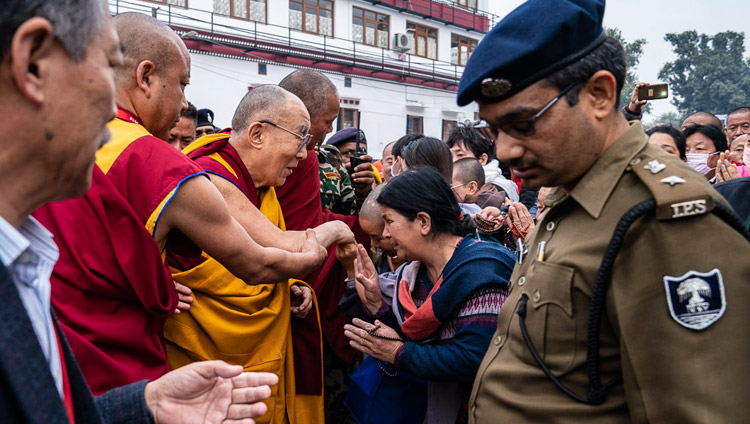 Sua Santità il Dalai Lama saluta amici e pellegrini mentre cammina verso il Tempio Mahabodhi a Bodhgaya, India, il 17 dicembre 2018. Foto di Tenzin Choejor