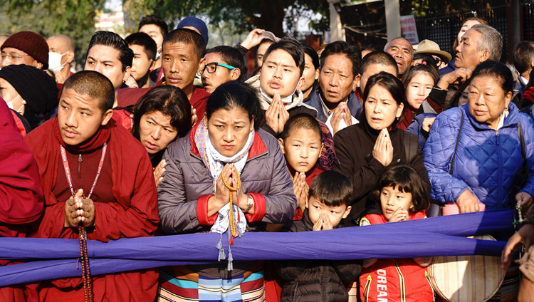 La gente assiepata lungo la strada, in attesa di vedere Sua Santità il Dalai Lama mentre dal monastero di Gaden Phelgyeling raggiunge il Kalachakra Ground, il secondo giorno dei suoi insegnamenti a Bodhgaya, India, il 25 dicembre 2018. Foto di Lobsang Tsering