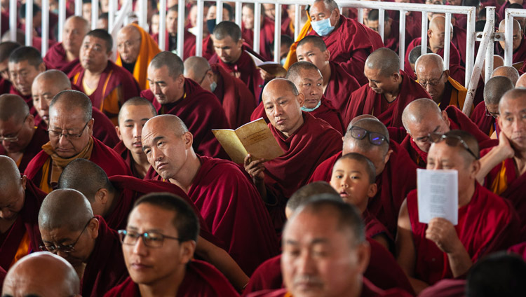 Alcuni degli oltre ottomila monaci e monache presenti seguono il testo durante il secondo giorno degli insegnamenti di Sua Santità il Dalai Lama a Bodhgaya, India, il 25 dicembre 2018. Foto di Lobsang Tsering