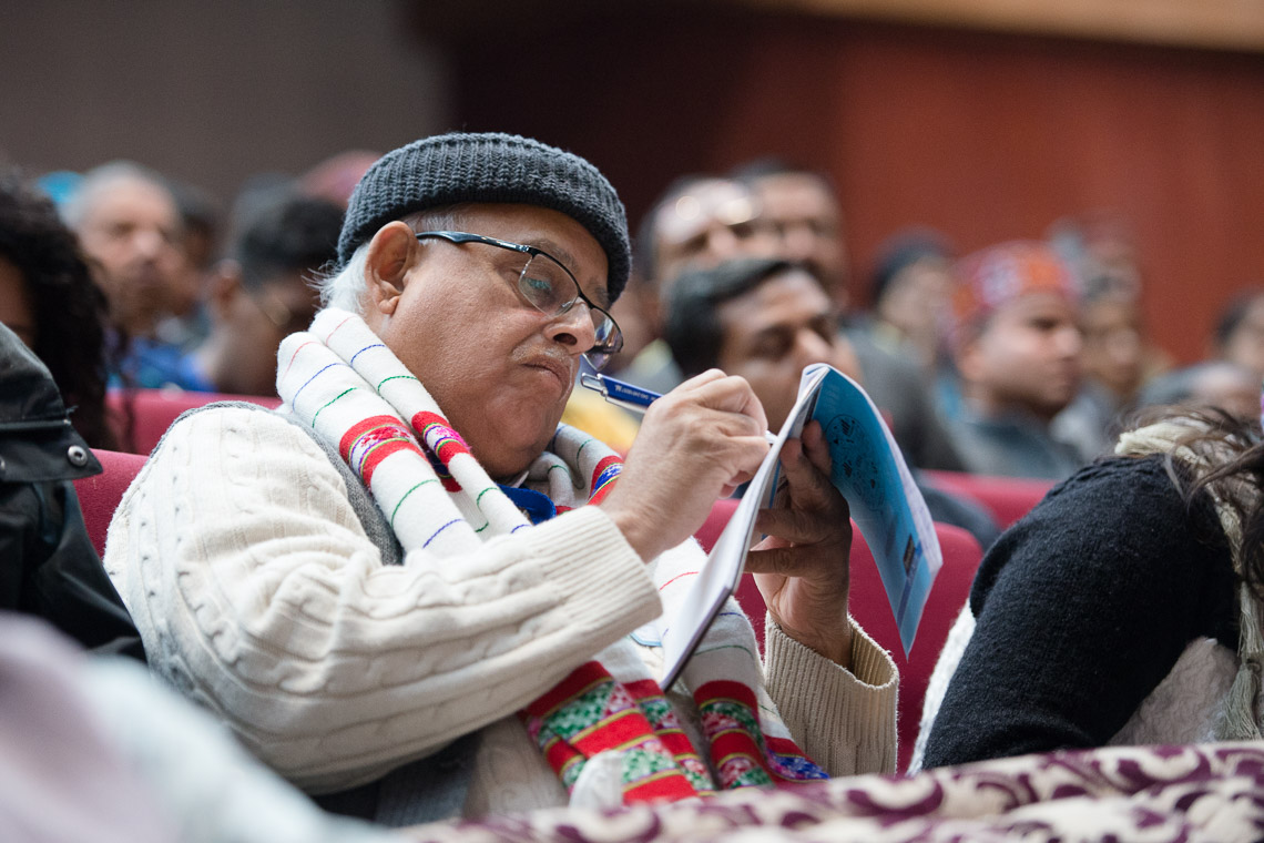 Un membro del pubblico prende appunti mentre Sua Santità il Dalai Lama parla durante la  Convention for Global Peace presso il Government College di Dharamsala, il 2 dicembre 2017. Foto di Lobsang Tsering